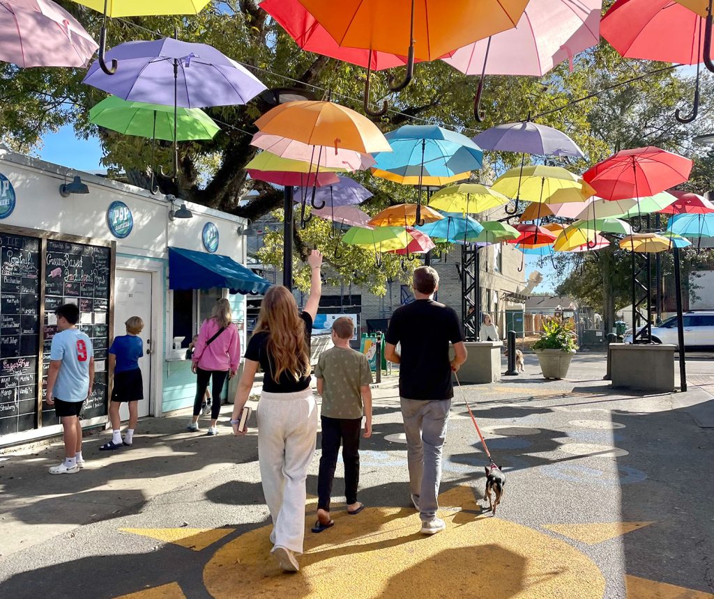 Kids Walking Under Bright Umbrellas In Cash Alley In Ocean Springs Mississippi