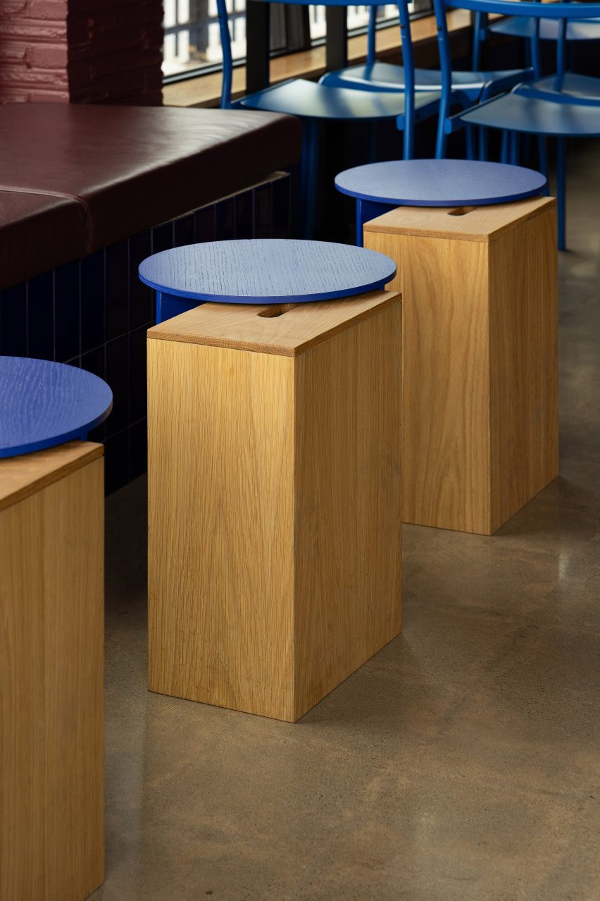 Row of wooden drinks tables with circular cobalt blue tops
